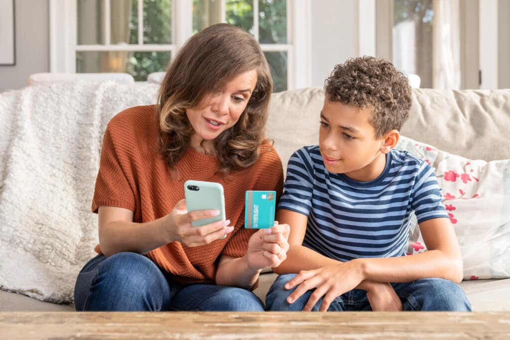 mom showing her son a greenlight credit card